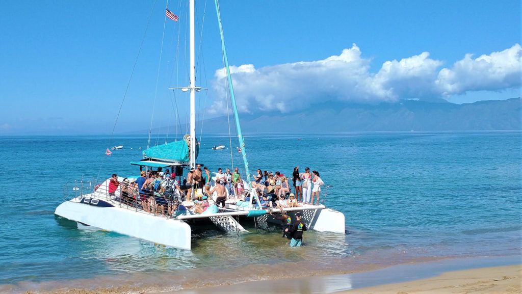 Sailing catamaran boarding for a tour on the beach in Ka'anapali on Maui.