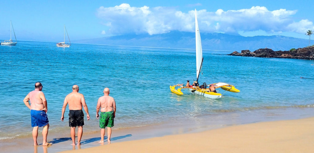 Hawaiian outrigger sailing canoe leaving the beach in Ka'anapali, Maui