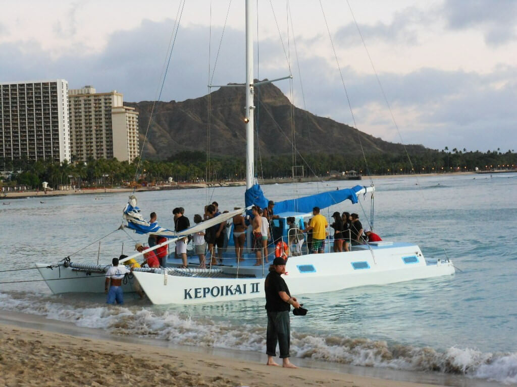 The Kepoikai II sailing catamaran charter boarding at Waikiki Beach