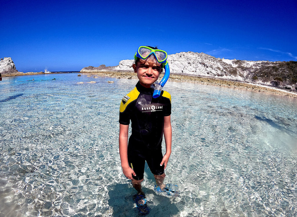 Young boy snorkeling near Exuma Sound on Pirate Trap Beach at Staniel Cay, Bahamas