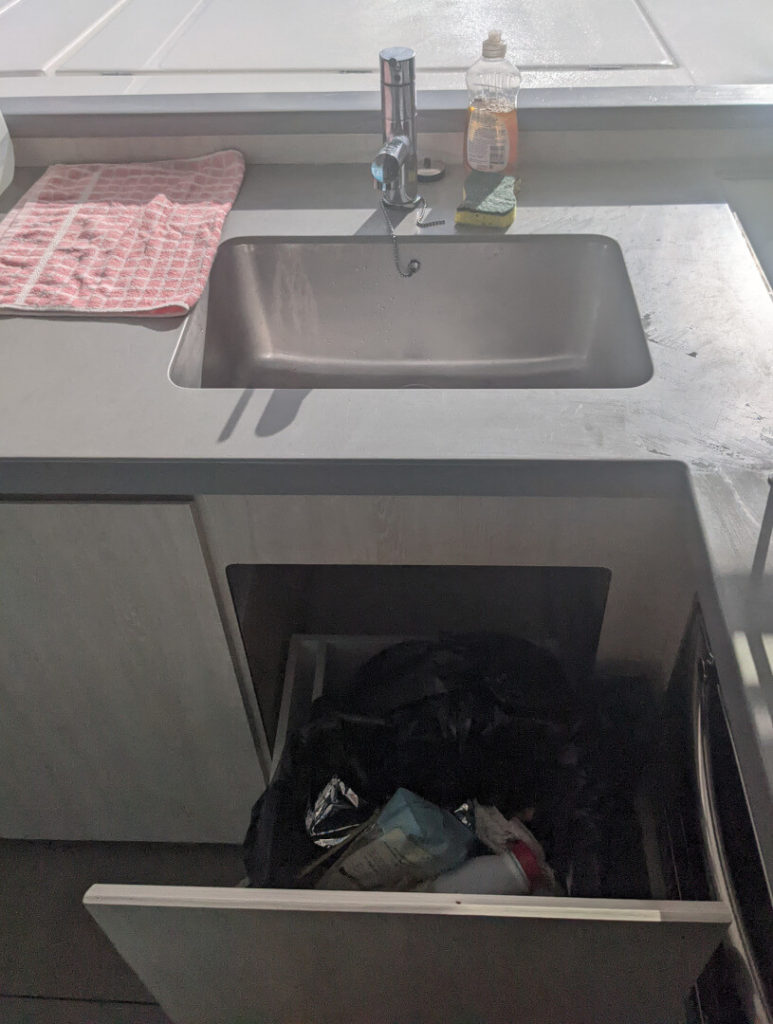 Garbage can below the sink
